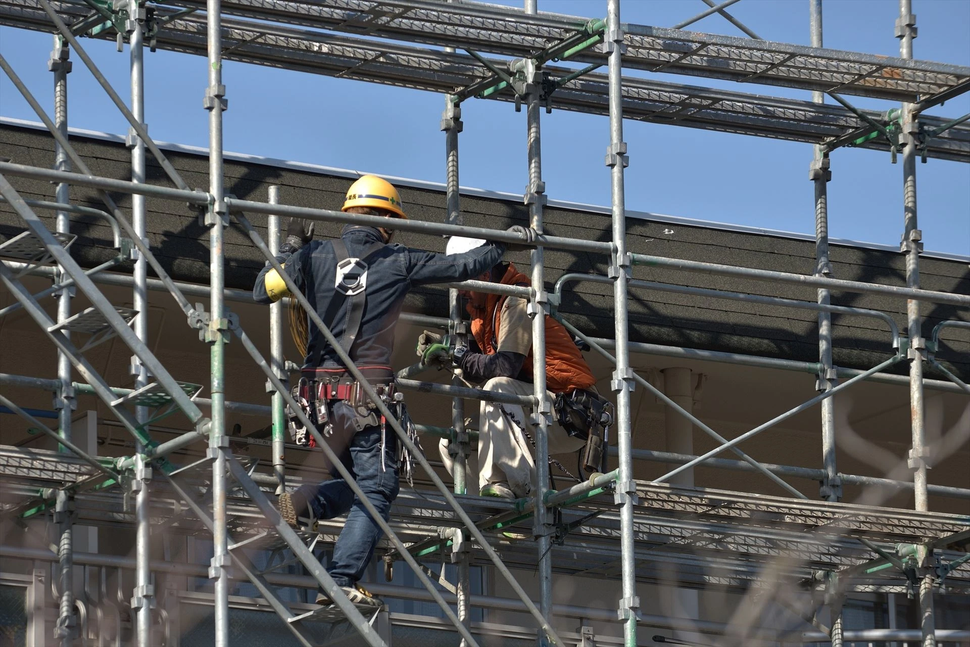 建枠を担ぐ職人